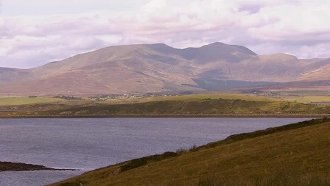 Landscape shot of green fields and blue water Stock Footage 87354018