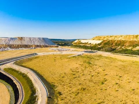 Landscape showing a large mining area with high cliffs and a wide road in s.. Stock Photos