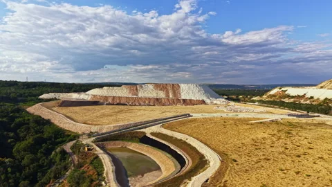 Landscape showing a large quarry with steep slopes and grass covered areas under Stock Footage 340880768