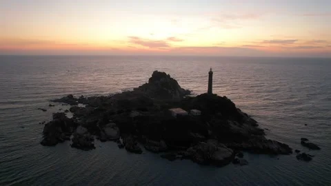 Landscape of small island with ancient lighthouse at sunrise sky Stock Footage 228660329