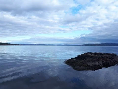 Landscape with a small island on the blue sea Stock Photos