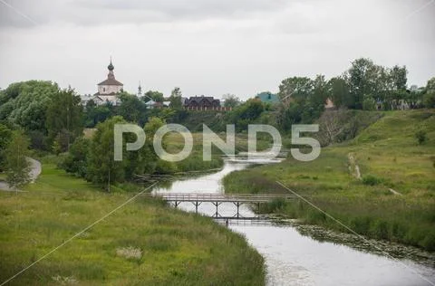 A landscape of small religious village - a bridge over the stream Stock Photos