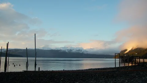 Landscape of snow covered mountains with shallow lake in front during sunset Stock Footage 129108034