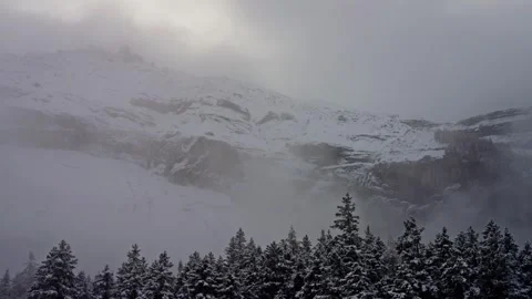 Landscape with snowy slopes, Trees Cloudy sky creating an atmospheric phenomenon Stock Footage 264045306