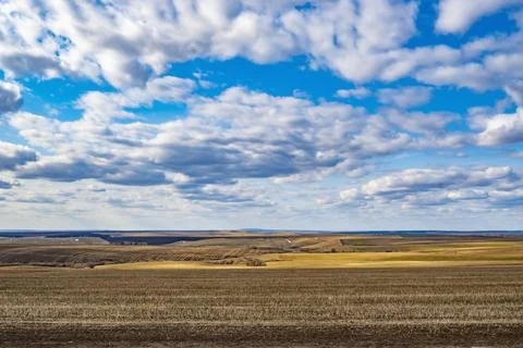 A landscape of spring fields with melting snow and dry grass Stock Photos