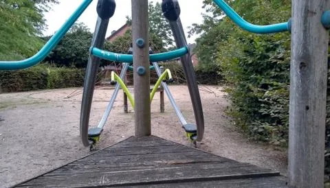 Landscape summer playground with colorful climbing equipment and lawn space Stock Photos