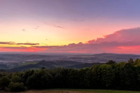 Landscape sunset with fully colored clouds pink orange sky look on meadow clo Stock-Fotos