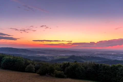 Landscape sunset with fully colored clouds pink orange sky look on meadow clo 스톡 사진