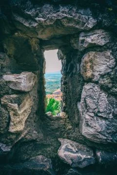 Landscape from a thin security window of an ancient stone wall. Stock Photos