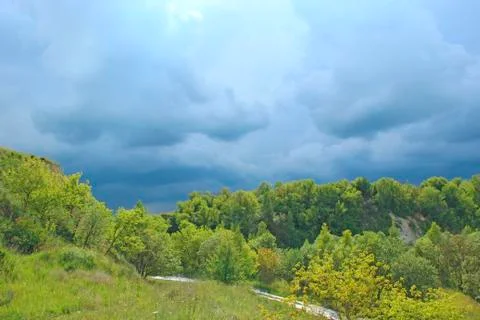Landscape with thundercloud over green forest. Stormcloud above green vegetat Stock Photos