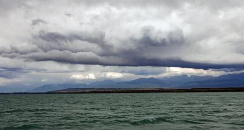 Landscape with thundercloud over the mountains and lake and the beginning of Stock Photos