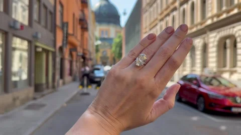 Landscape video of a hand moving through city streets with an engagement ring Stock Footage 316817669