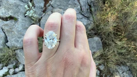 Landscape video oval diamond ring closeup moving light on rocky cliff Stock Footage 319456011