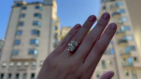 Landscape video of solitaire engagement ring with oval diamond in city view Stock Footage 316692712