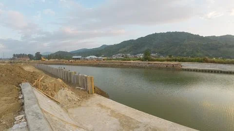 Landscape view of a construction site with a dam in the background Stock Photos