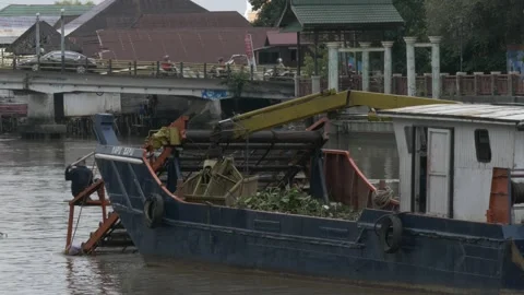 Landscape view, debris skimmer cleaning up Martapura river Stock Footage 156996323