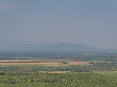 Landscape view of fields and forest with distant mountain Stock Photos
