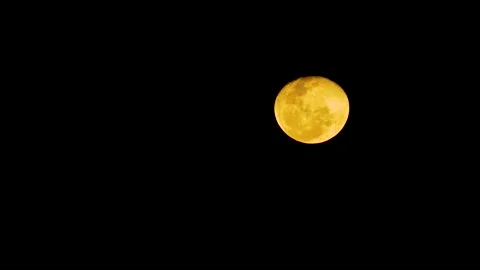 Landscape view of a full moon glowing brightly in the dark nighttime sky with a Stock Footage 345182572