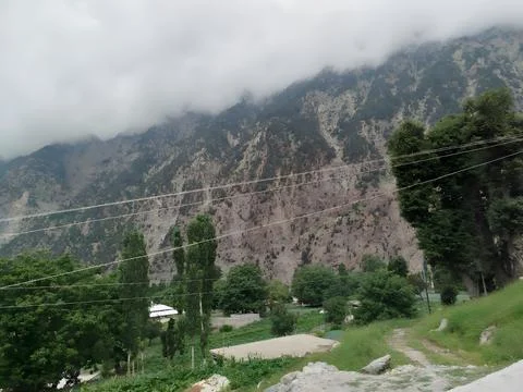 Landscape view of a mountain range covered with clouds and trees Stock Photos