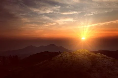 Landscape view of a mountain range with mist during sunrise or sunset. Natu.. Stock Photos