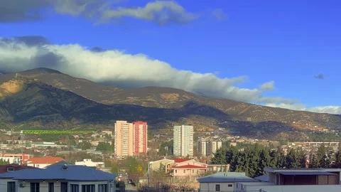 Landscape view of mountains, clouds, blue sky, suburban residential area Stock Footage 308128192