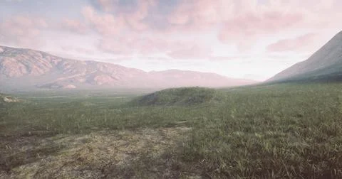 Landscape view of rolling hills and distant mountains during sunset Stock Illustration