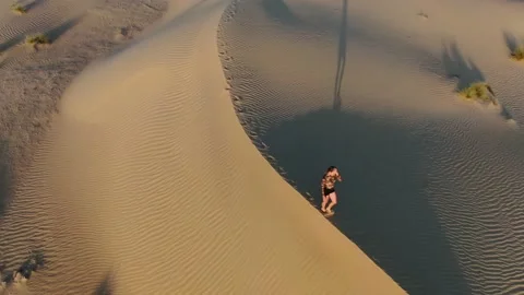 Landscape view on Rub al Khali desert with a woman walking on a dune, 4k Stock Footage 152886314