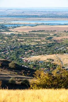 Landscape view of a rural area with fields, houses, and a river in the dist.. Stock Photos