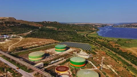 Landscape view of storage tanks and solar panels near a river Stock Footage 340383616
