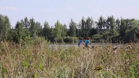 Landscape view Two cyclists driving along the shore of the lake Video stock 93883964