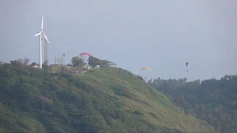 Landscape view with wind mill and three paragliders. Slow motion 動画素材 70359272
