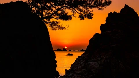 A landscape where the red sun rises among the rocks. Zoom out Stock Footage 145740037