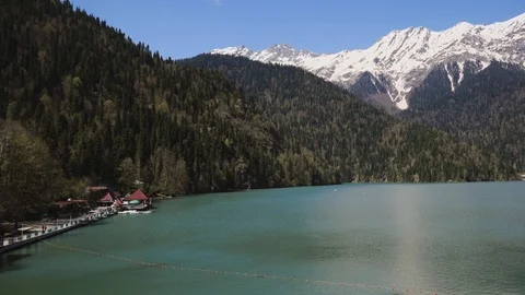 Landscape where we see a building, a forest with trees and mountains in the snow Stock Footage 89896852