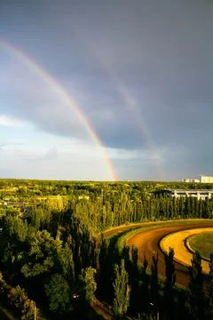 Landscape with wild field dramatic sky and rainbow. Rainbow between the sky a Stock Photos