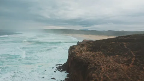 Landscape of wild ocean coast with waves and a van shot by drone Stock Footage 203598317