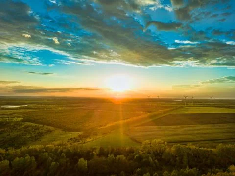 Landscape the wind wheels with a bright undergoing sun in the horizon, renewable Stock Photos