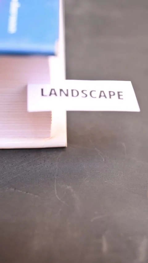Landscape Word on Paper Note with Hand and Book in Vertical Close Up Stock Footage 336880895