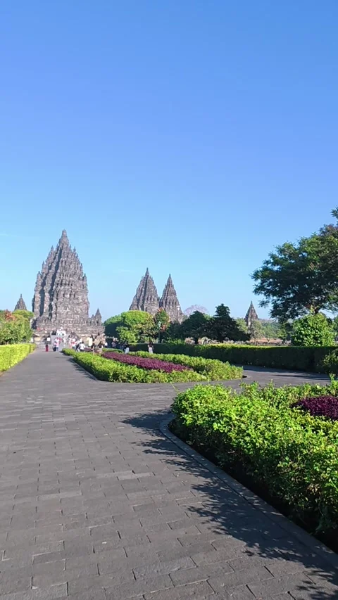 Landscaped pathway leads toward the distant spires of Prambanan Temple bene.. Stock Footage 341542998
