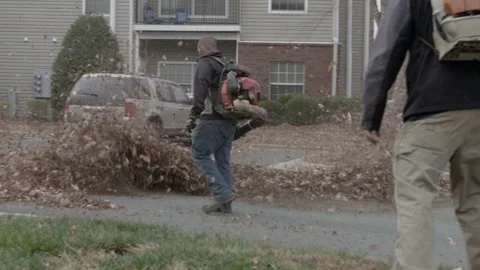 Landscapers Using Leaf Blowers in Residential Lot Stock Footage 343937671