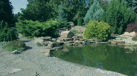 The landscaping flying camera over small lake and waterfall Stock Footage 47070473