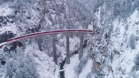 Landwasser Viaduct and Train in Winter. Swiss Alps. Switzerland. Aerial View Stock Footage