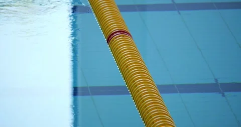 Lane divider with red markers drifting across swimming pool, generating soft Stock Footage 313594989