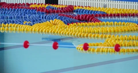 Lane lines floating gracefully across smooth indoor pool surface, forming Stock Footage 313594862