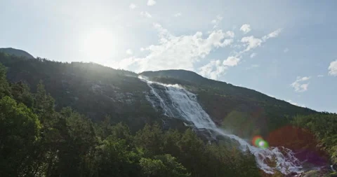 Langfossen waterfall backlit by the sun with lens flare over pine forest 스톡 동영상 317087003