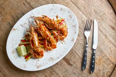Langoustines cooked on open fire with salsa of lime mango and chili on a wood Stock Photos
