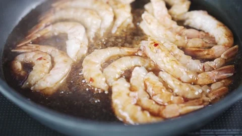 Langoustines in sauce cooking process. Slow motion view of shrimps in the Stock Footage 231673565