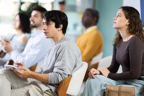 Language courses university - man with other students listens to the teacher and Stock Photos