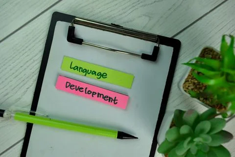 Language Development write on sticky notes isolated on Wooden Table. 스톡 사진