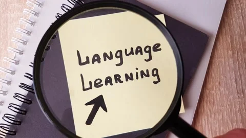 LANGUAGE LEARNING, text note note taking through a magnifying glass Stock Footage 313432098