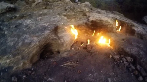Languages flames burst from under the stone, around the plant, mountain, rocks Stock Footage 115840416
